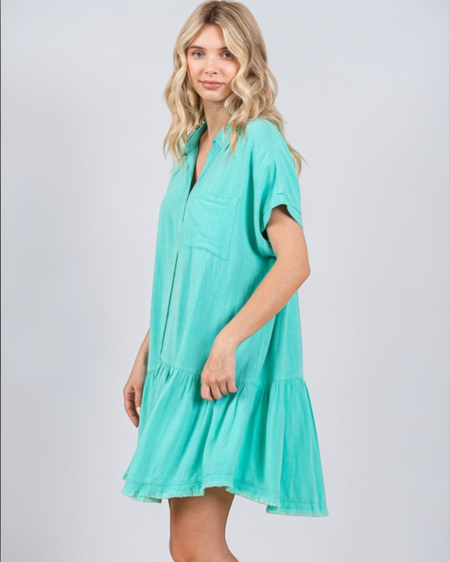 Woman wearing a teal dress on a white background