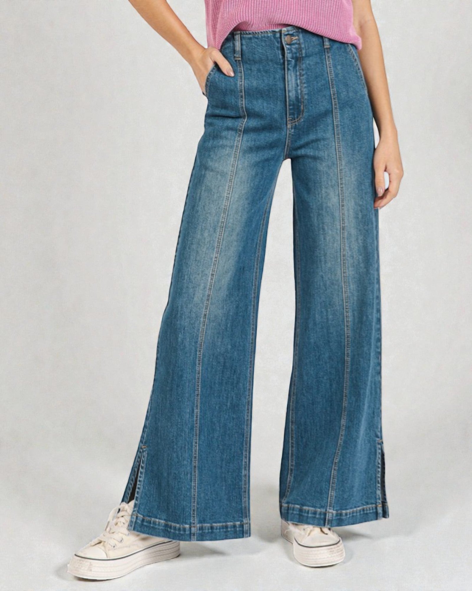 Person wearing blue wide-leg jeans on a plain background