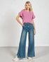 Woman wearing a pink top and blue jeans on a white background