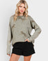 Woman wearing a green sweater with leopard prints on a white background