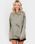 Woman wearing a long-sleeve top with animal prints on a plain background