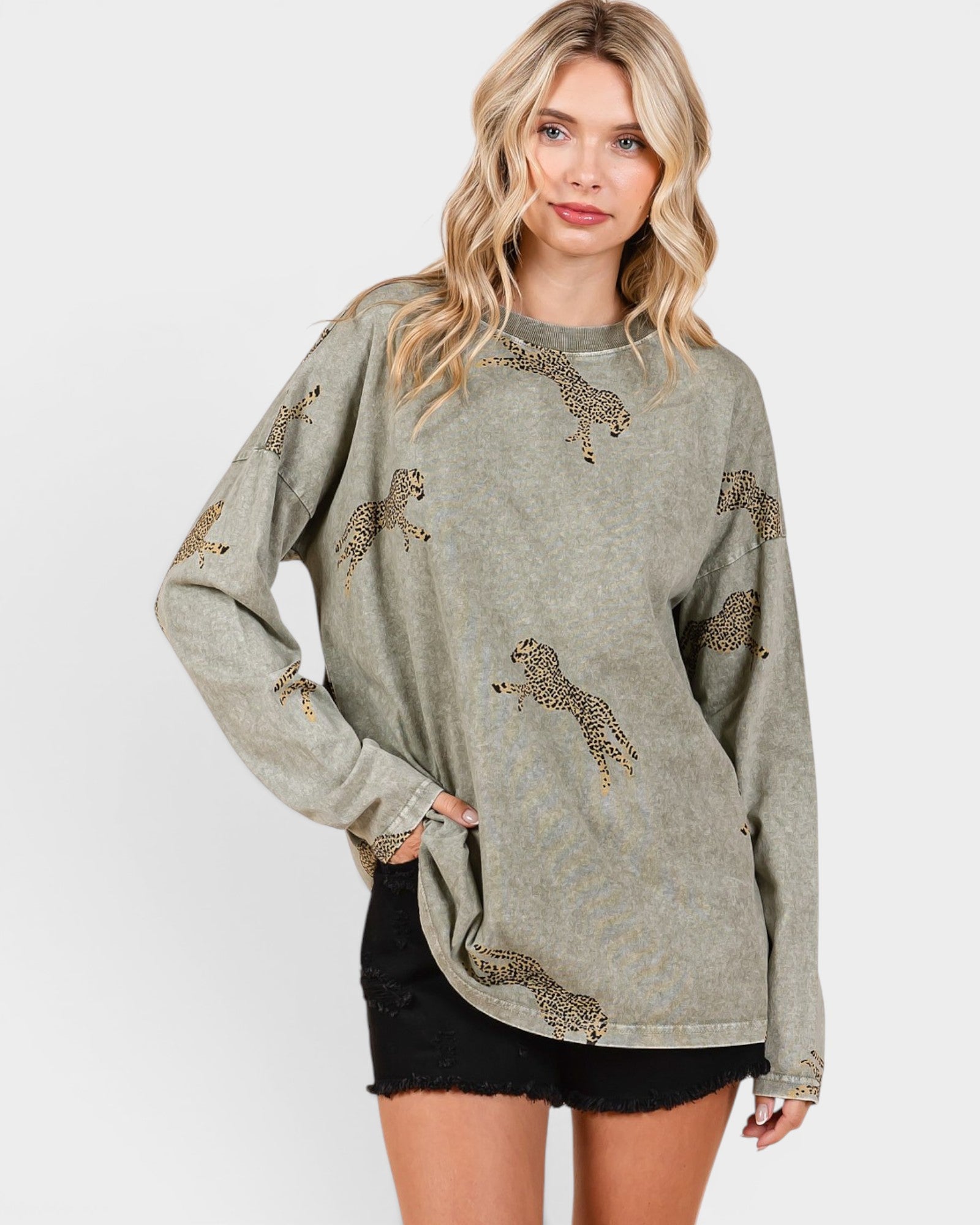 Woman wearing a green sweater with animal prints on a white background