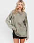 Woman wearing a green sweater with animal prints on a white background