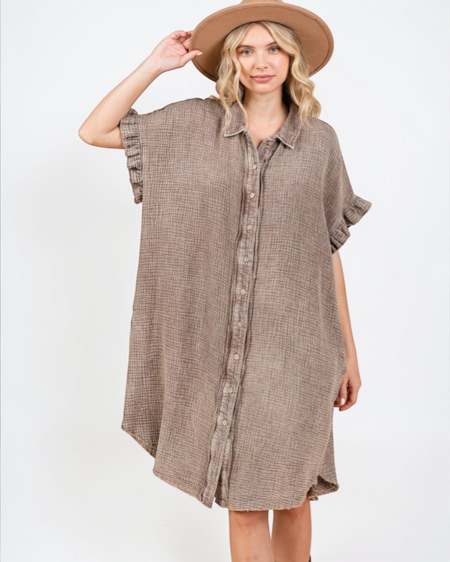 Woman wearing a brown checkered dress and hat on a white background