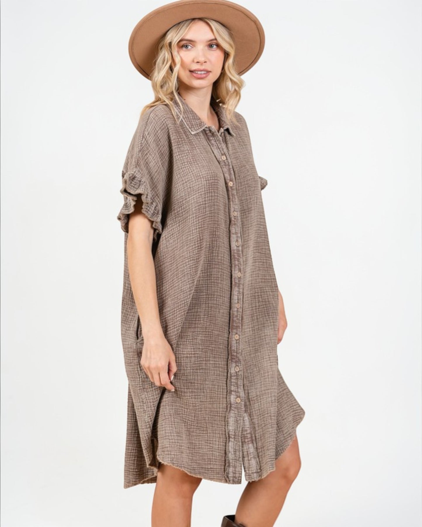 Woman wearing a brown checkered dress and hat on a white background