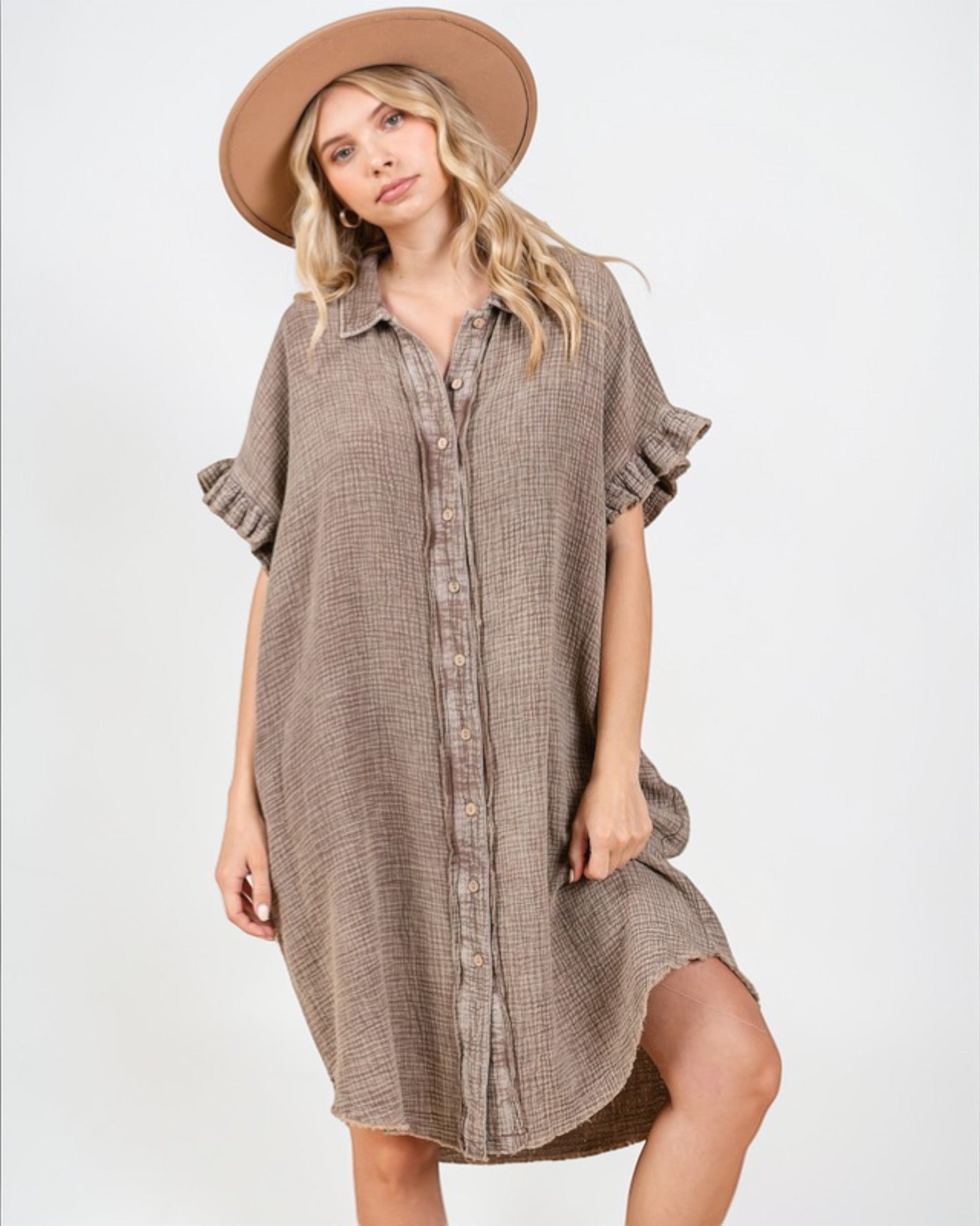 Woman wearing a brown checkered dress and hat on a white background