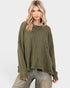 Woman wearing an olive green waffle knit sweater on a white background