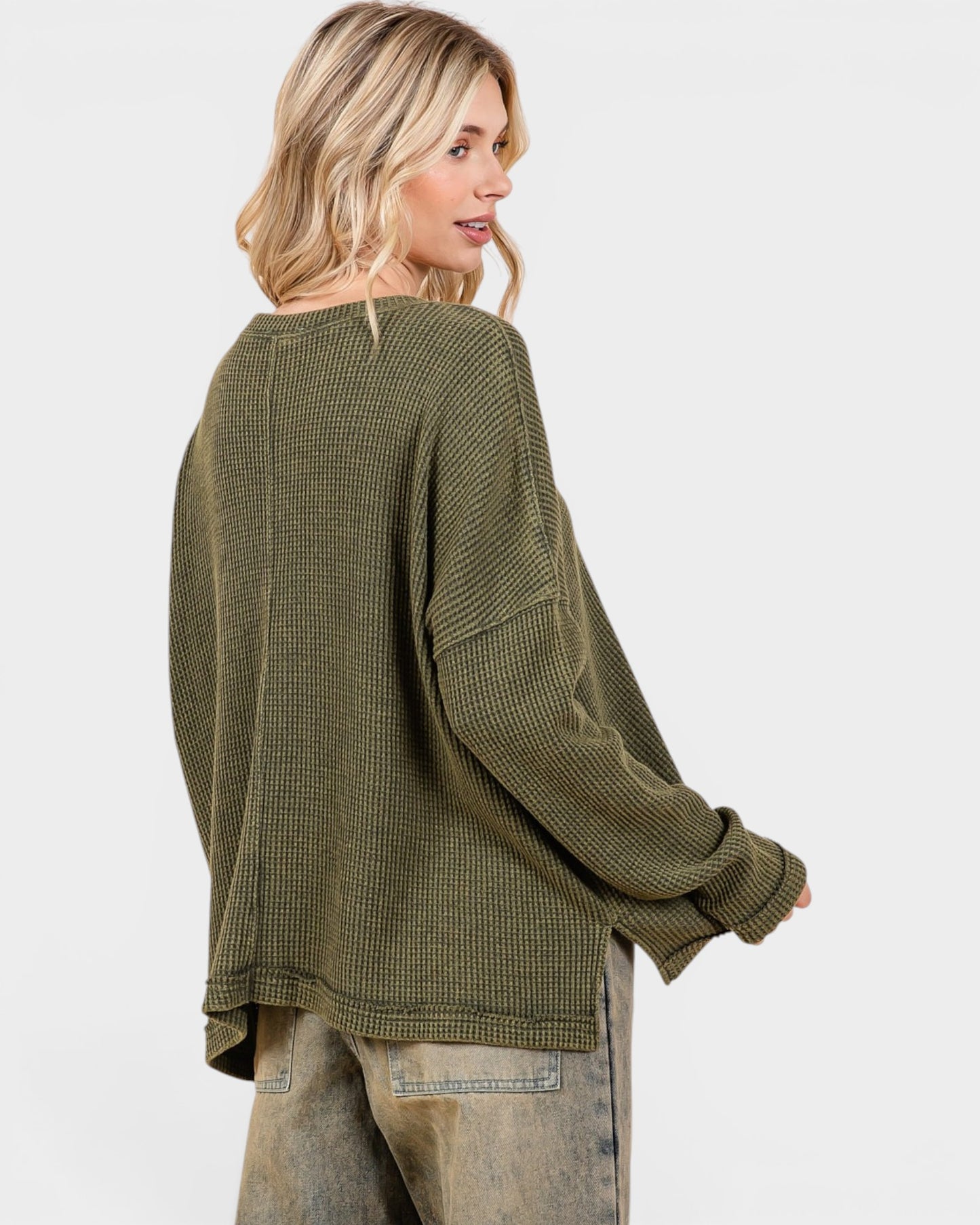 Woman wearing a green textured sweater on a white background