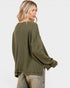 Woman wearing a green textured sweater on a white background