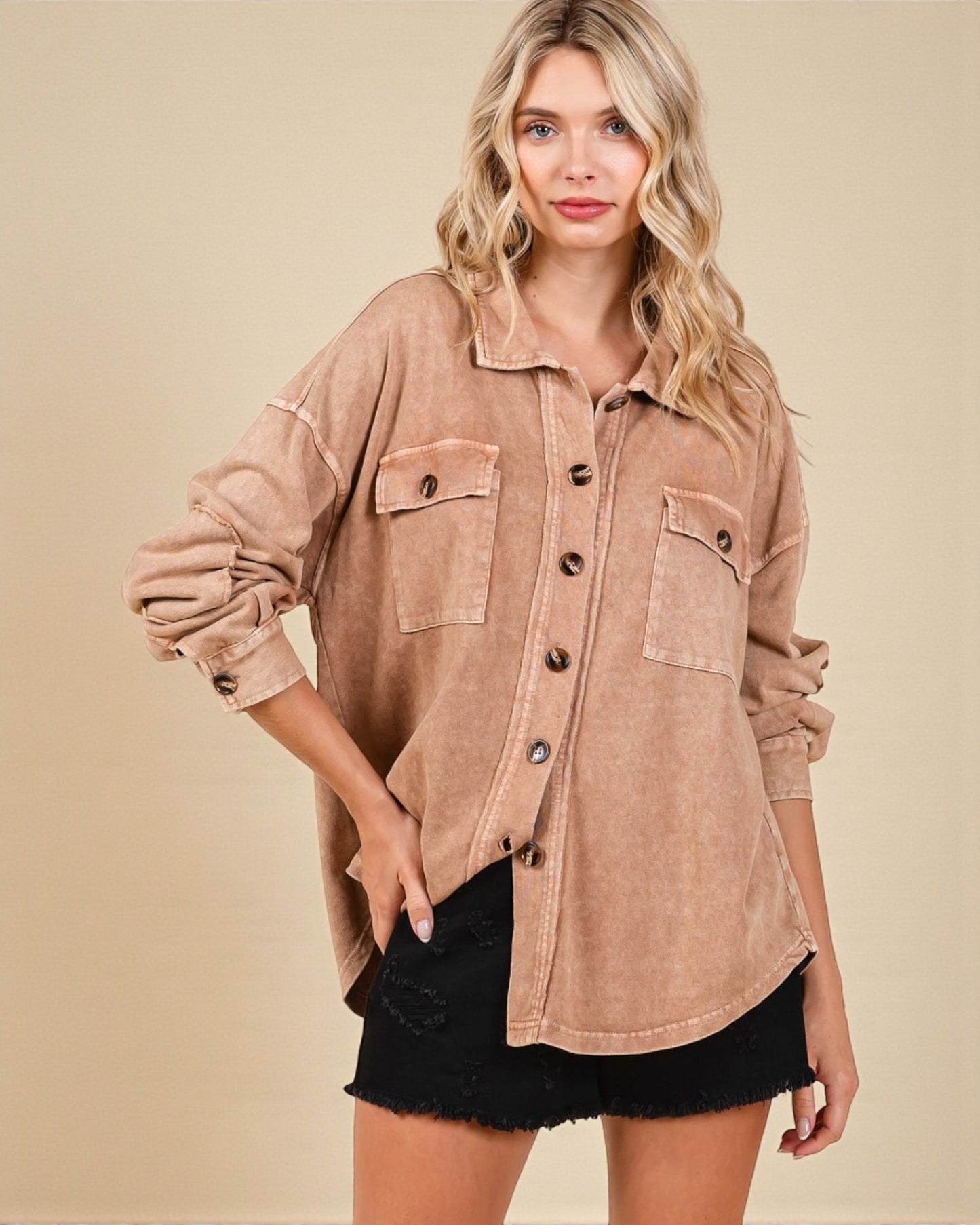 Woman wearing a brown button-up shirt with a beige background