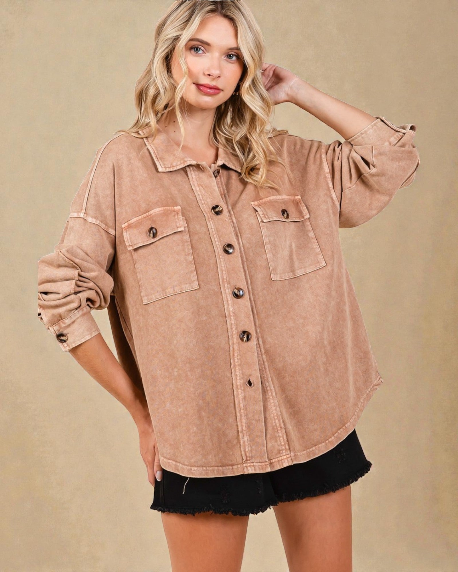 Woman wearing a beige button-up shirt with a plain background