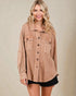 Woman wearing a beige button-up shirt against a beige background
