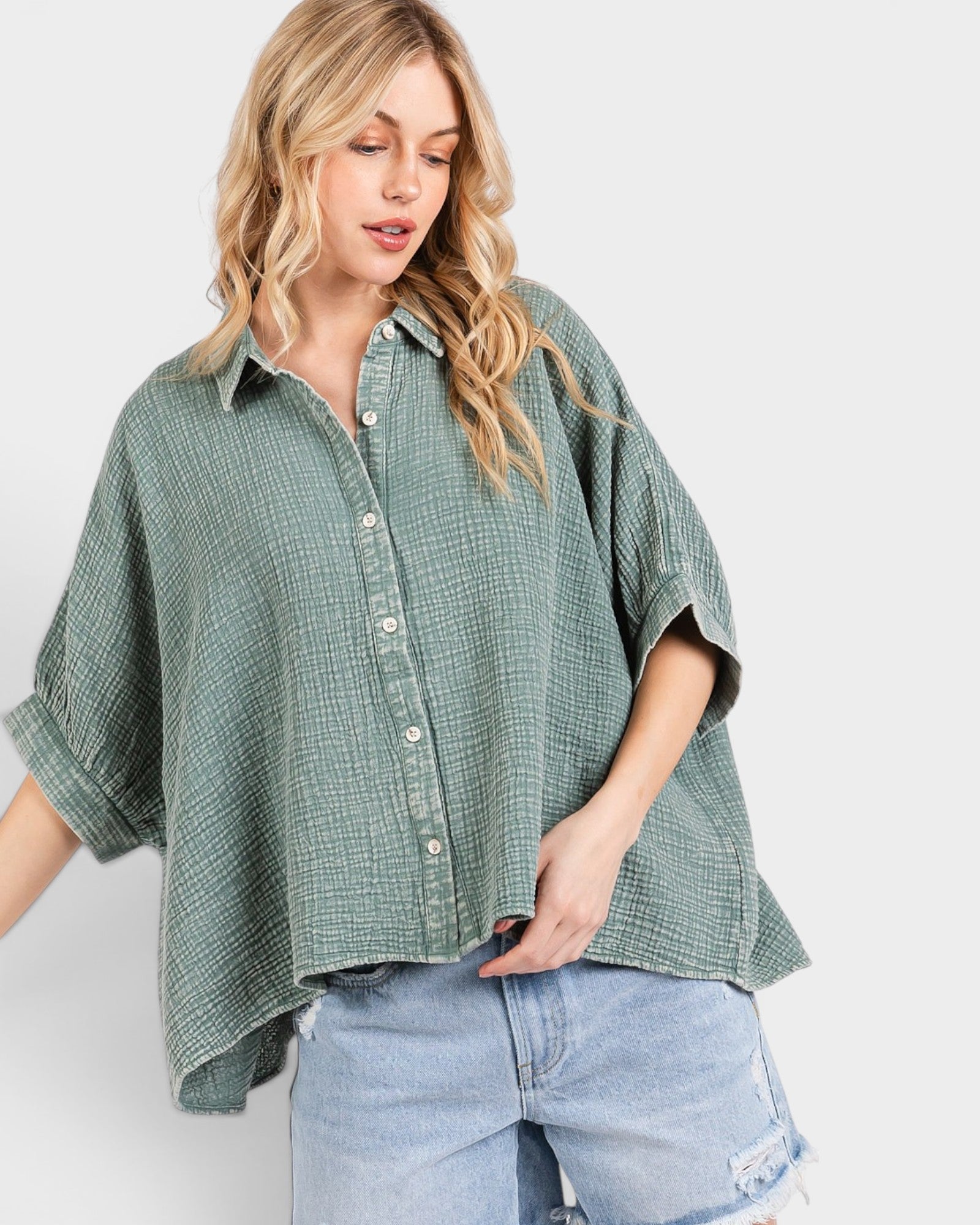 Woman wearing a green checkered shirt and light blue jeans on a white background