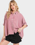 Woman wearing a pink plaid shirt and black shorts on a white background