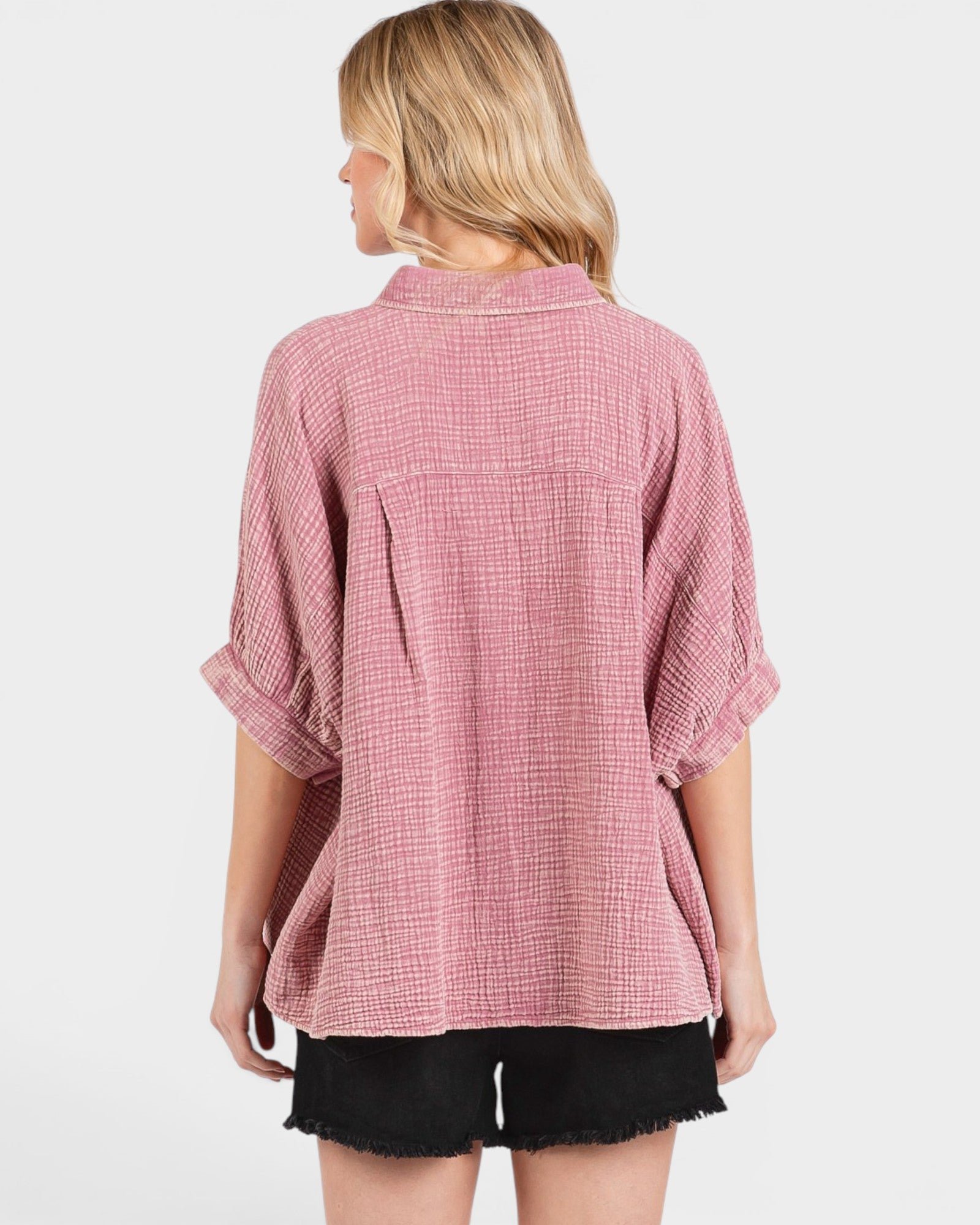Person wearing a pink plaid shirt on a white background
