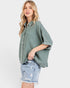 Woman wearing a green checkered shirt and denim shorts on a white background