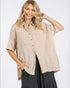 Woman wearing a beige button-up shirt with a white background