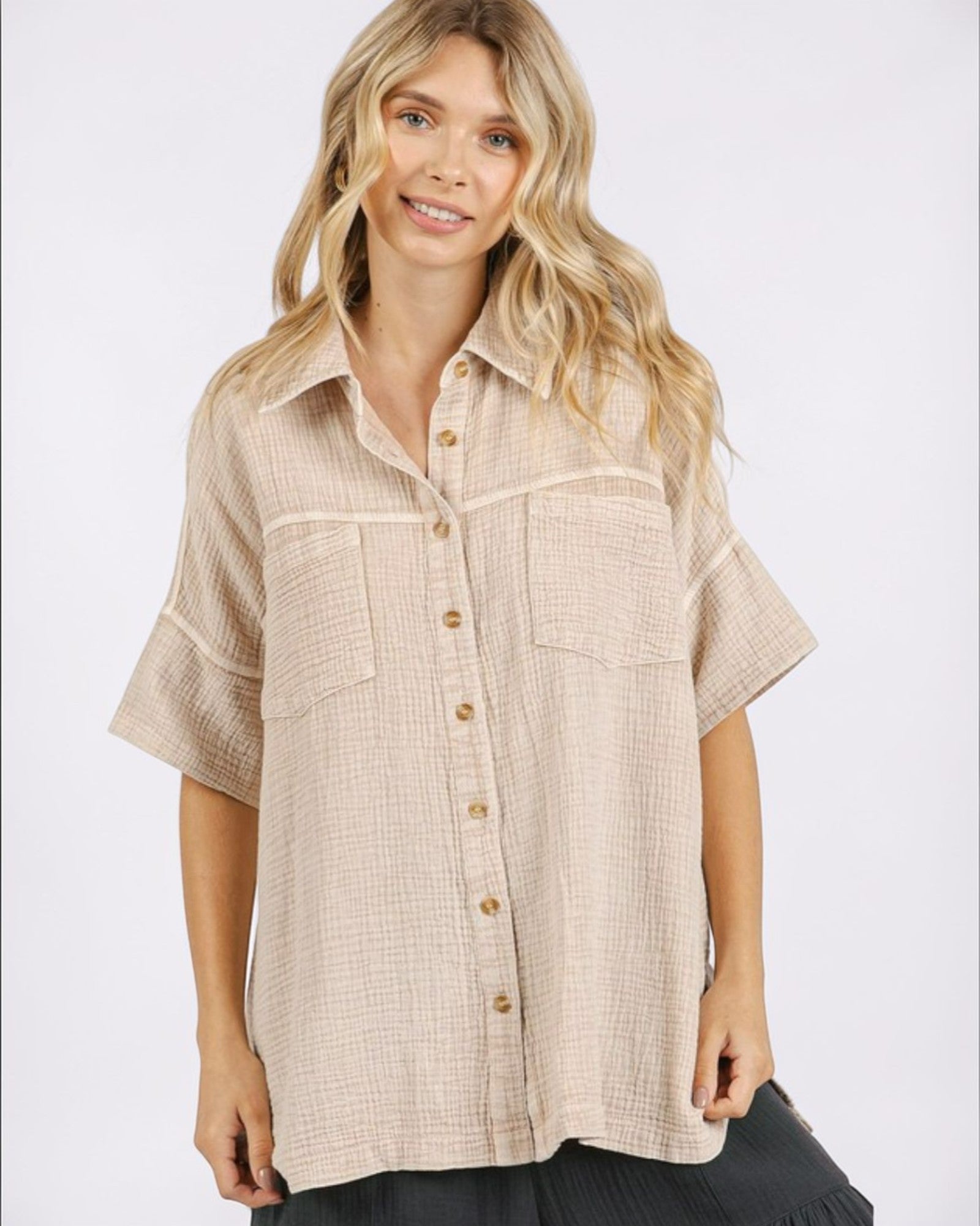 Woman wearing a beige button-up shirt on a white background