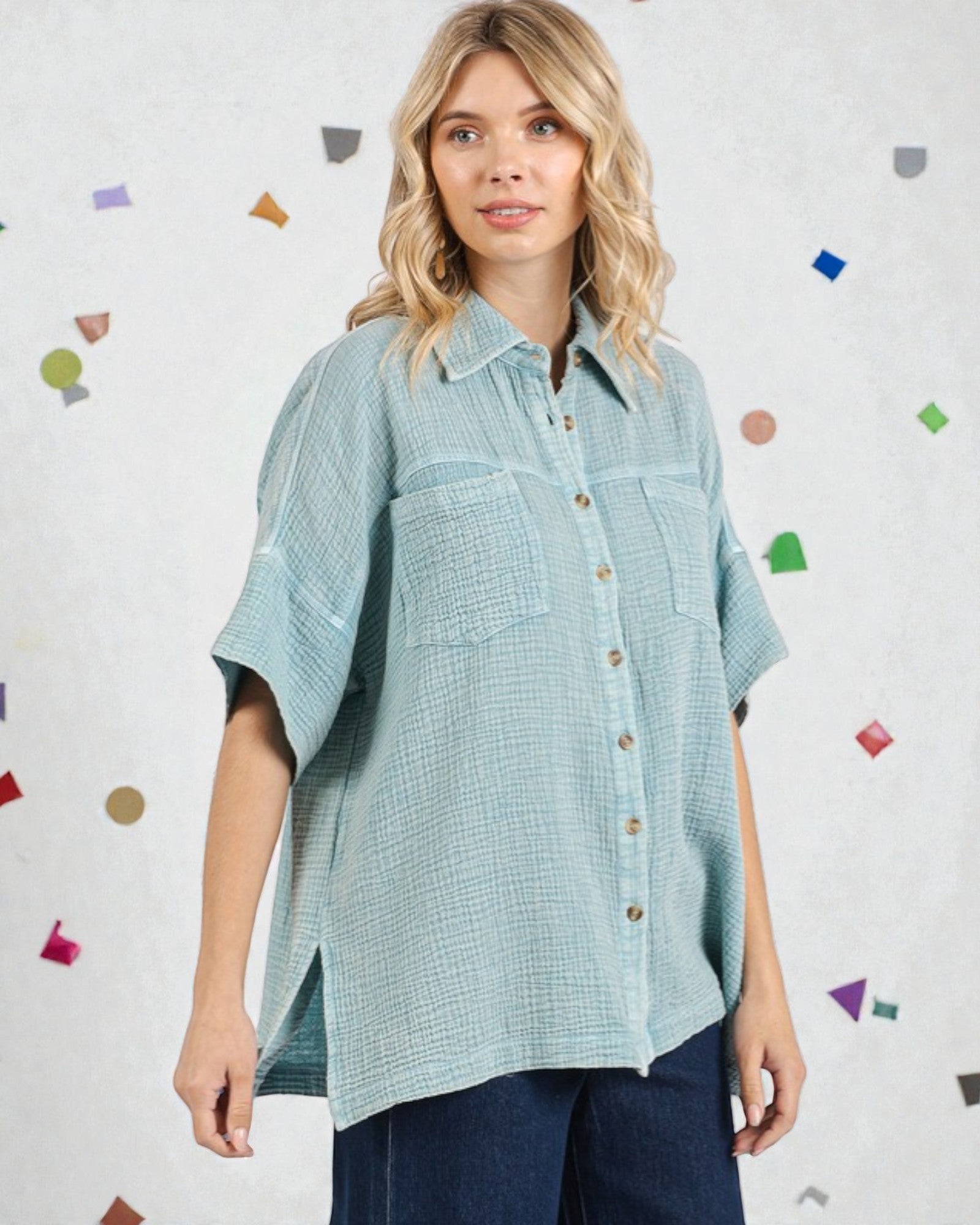 Woman wearing a light blue checkered shirt against a colorful polka dot background
