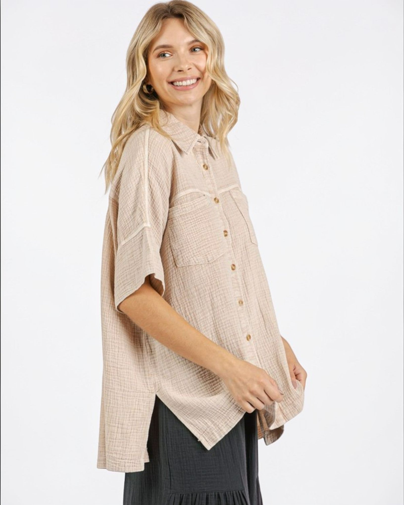 Woman wearing a beige textured blouse with a white background