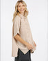 Woman wearing a beige textured blouse with a white background