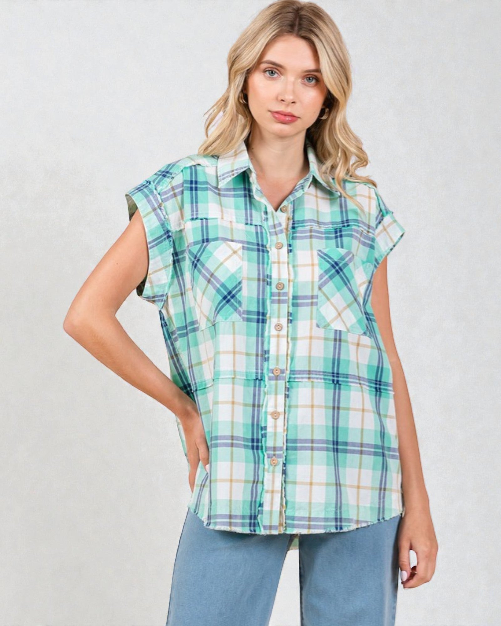 Woman wearing a plaid shirt with short sleeves on a plain background