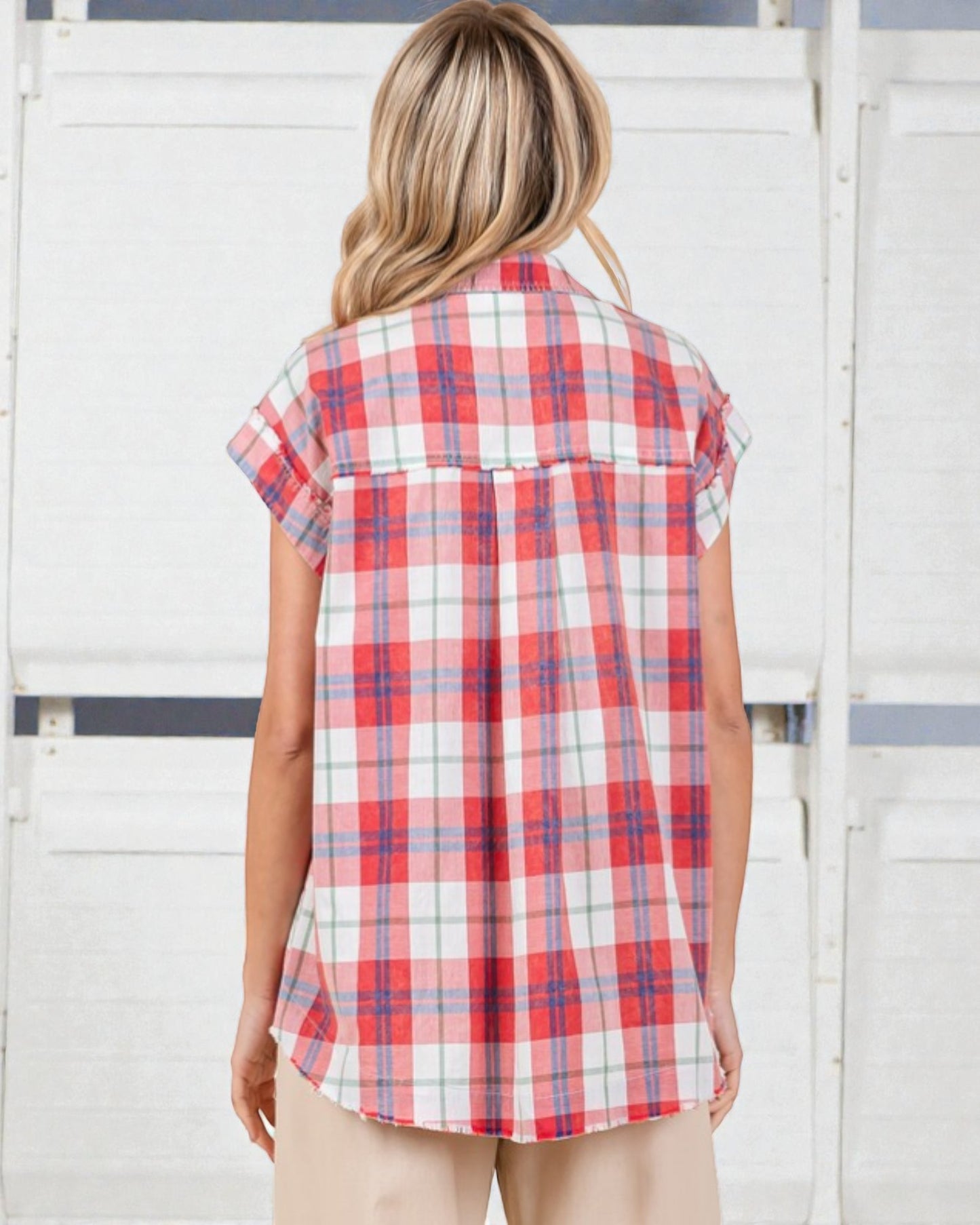 Woman wearing a red and white plaid shirt against a white background