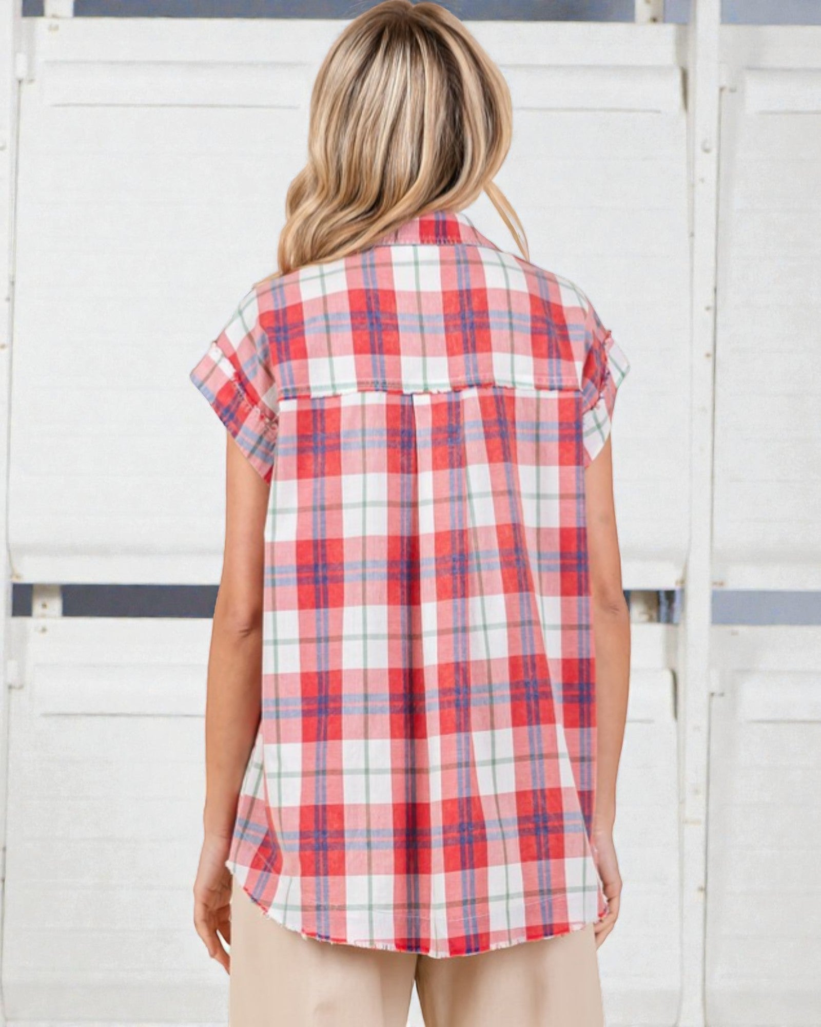 Woman wearing a red and white plaid shirt against a white background