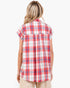A woman shown from the back wearing a red, white, and blue plaid short-sleeve button-up shirt, paired with beige pants, against a plain white background.