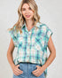 Woman wearing a plaid shirt with short sleeves on a plain background