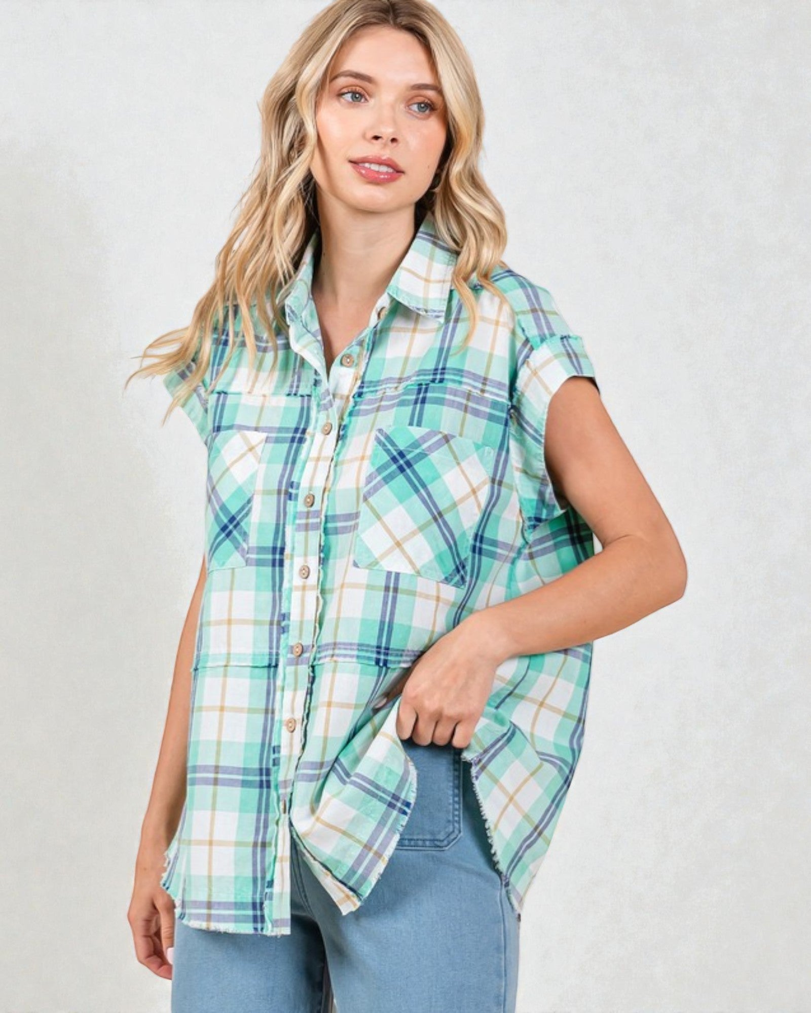 Woman wearing a plaid shirt with short sleeves on a plain background