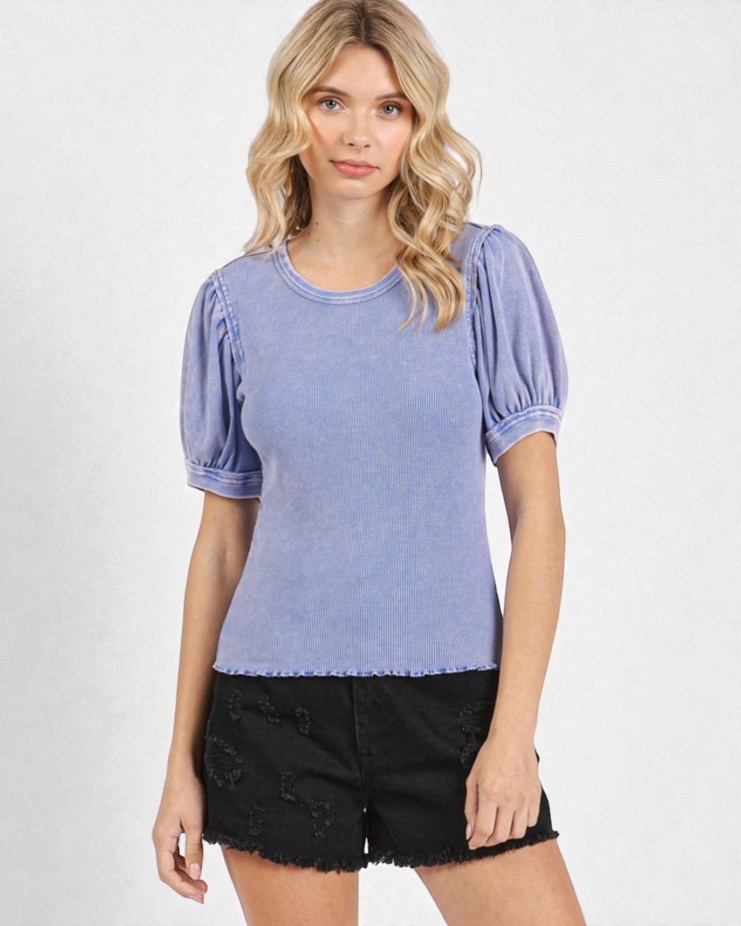 Woman wearing a blue top with puffed sleeves on a white background