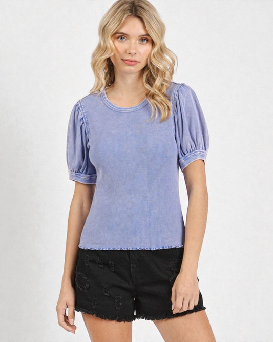 Woman wearing a blue top with puffed sleeves on a white background