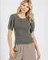 Woman wearing a gray top with puff sleeves on a white background