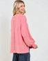 Woman wearing a pink long-sleeve top on a white background