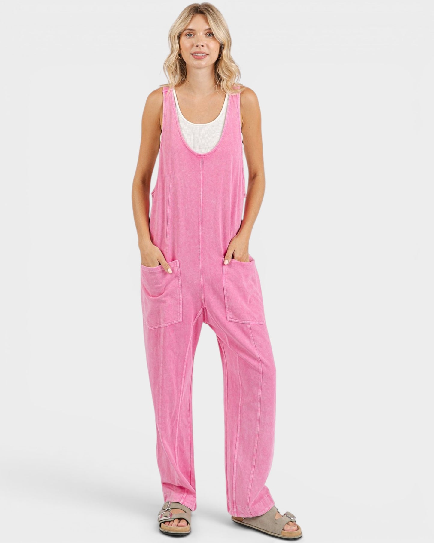 Woman wearing a pink jumpsuit on a white background