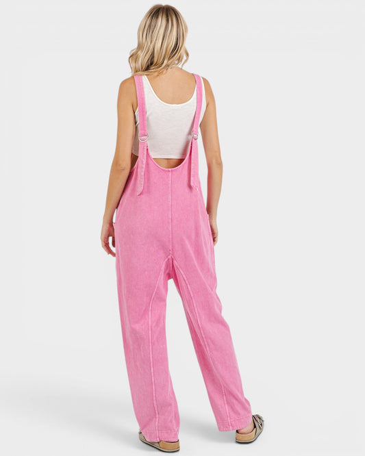 Person wearing pink overalls on a white background