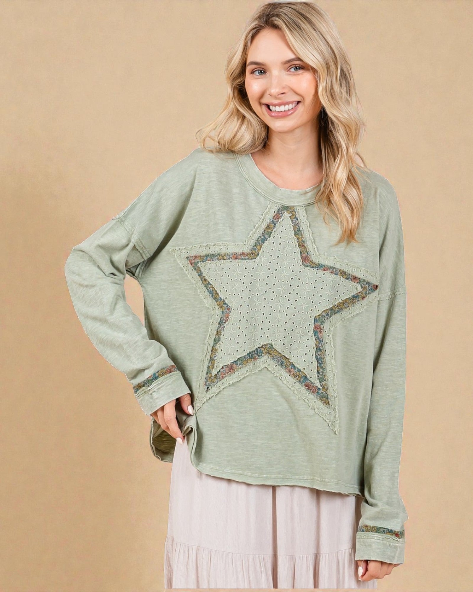 Woman wearing a green sweater with a star design on a beige background