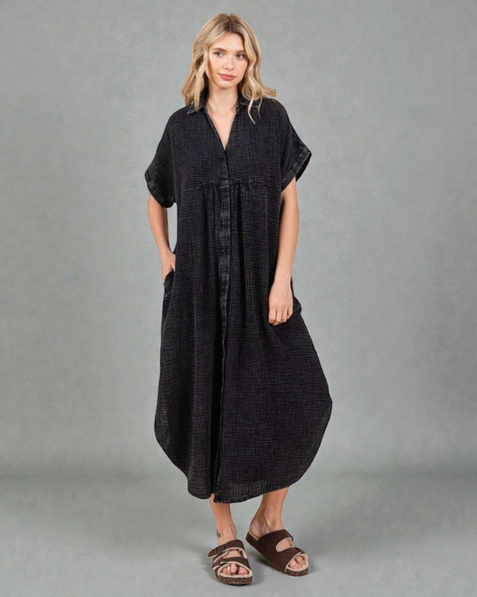 Woman wearing a black dress against a gray background