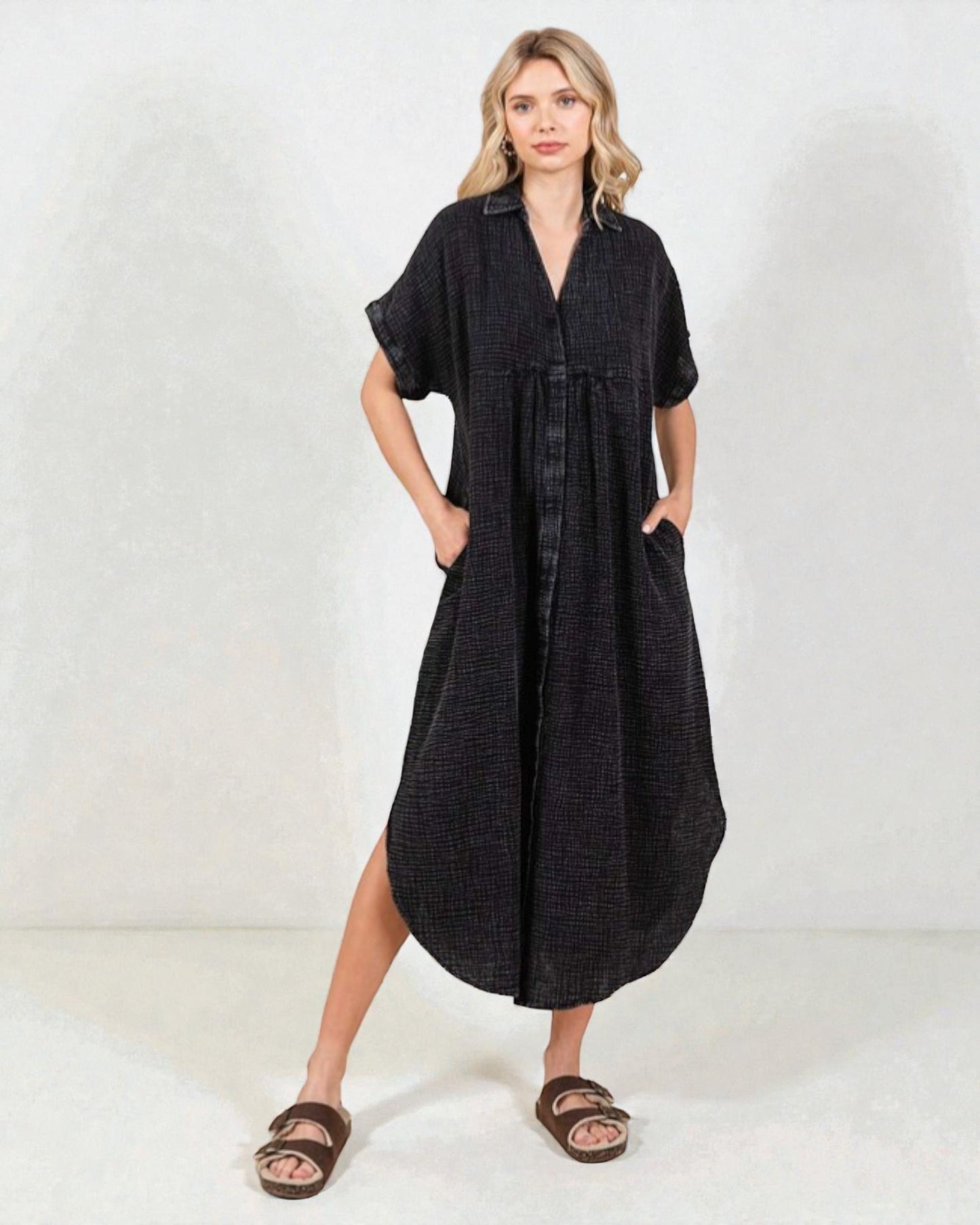 Woman wearing a black dress with short sleeves on a white background