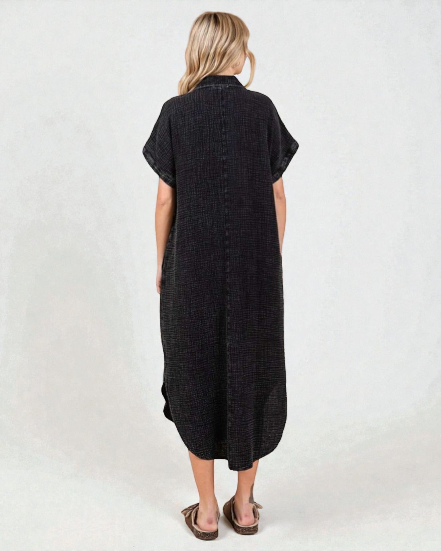 Woman wearing a black dress with short sleeves on a white background