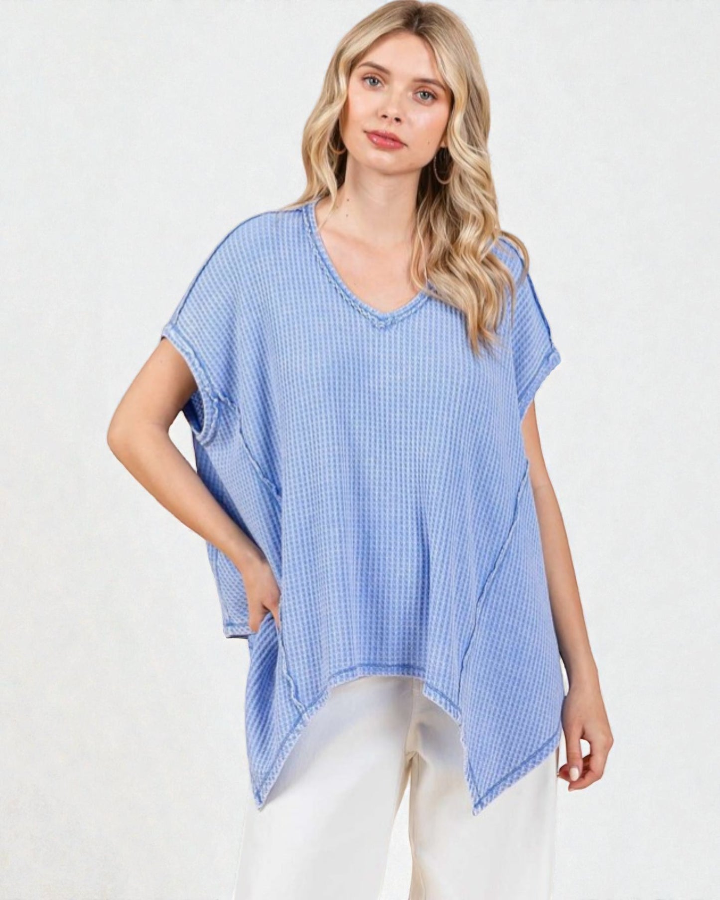 Woman wearing a blue checkered poncho on a white background