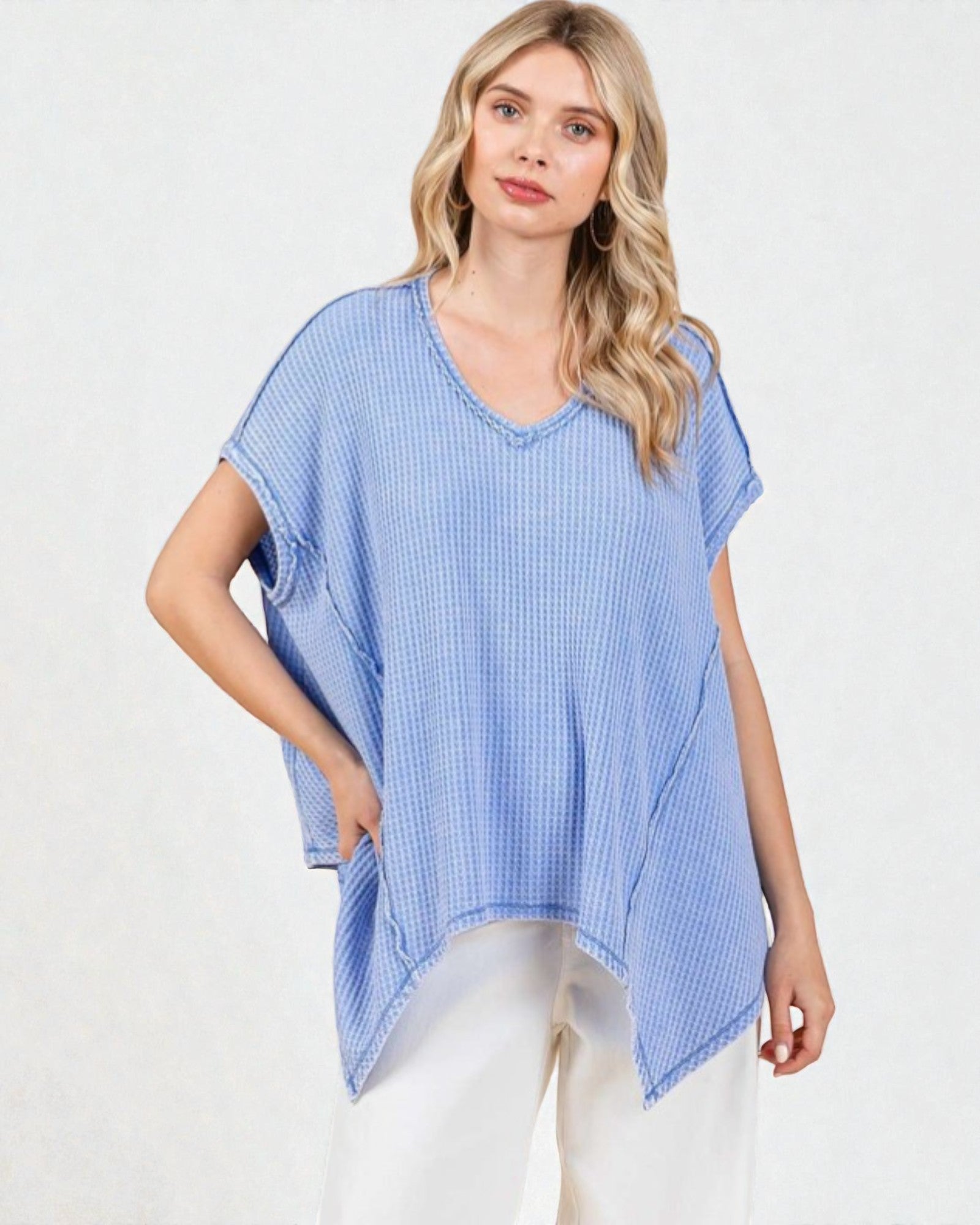 Woman wearing a blue checkered poncho on a white background