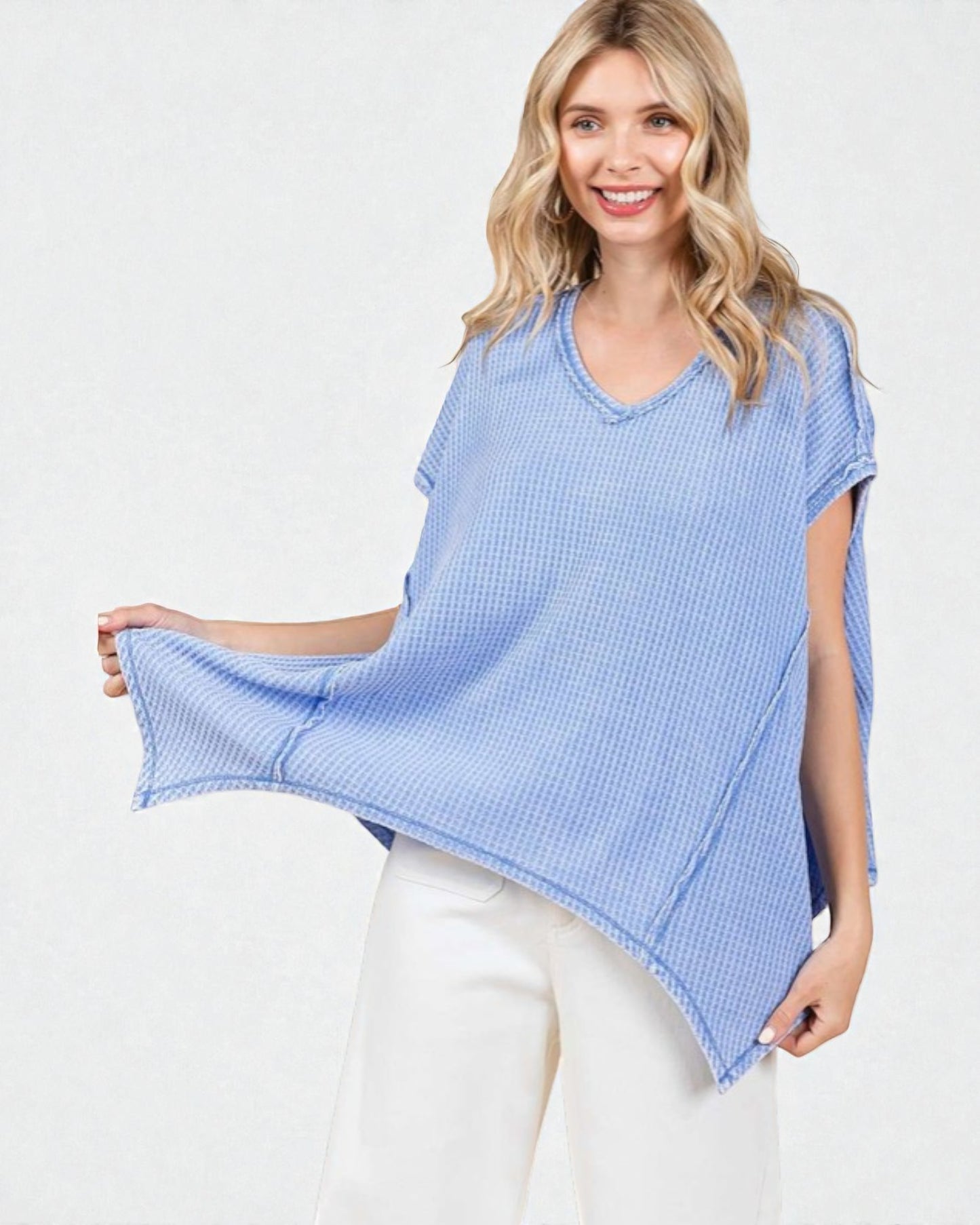 Woman wearing a blue checkered top and white pants on a white background