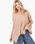 A woman wearing a beige waffle-knit short-sleeve top with an asymmetrical hem and blue jeans, photographed against a clean white background.
