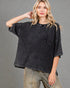 Woman wearing a black textured shirt with a pocket on a gray background