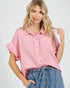 Woman wearing a pink button-up shirt and blue jeans on a white background