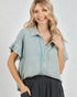 Woman wearing a light blue checkered shirt with ruffled sleeves on a white background