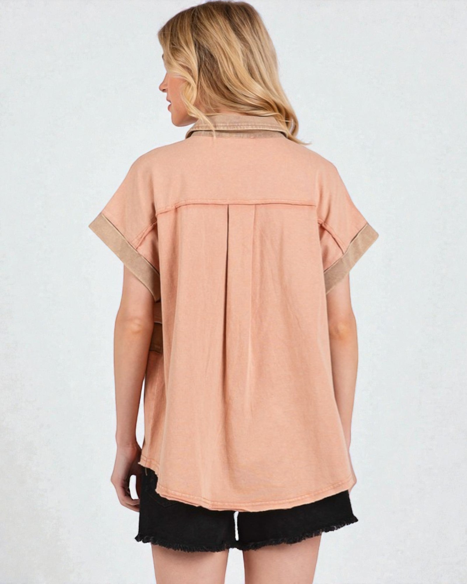 Woman wearing a peach-colored shirt with beige accents on a white background