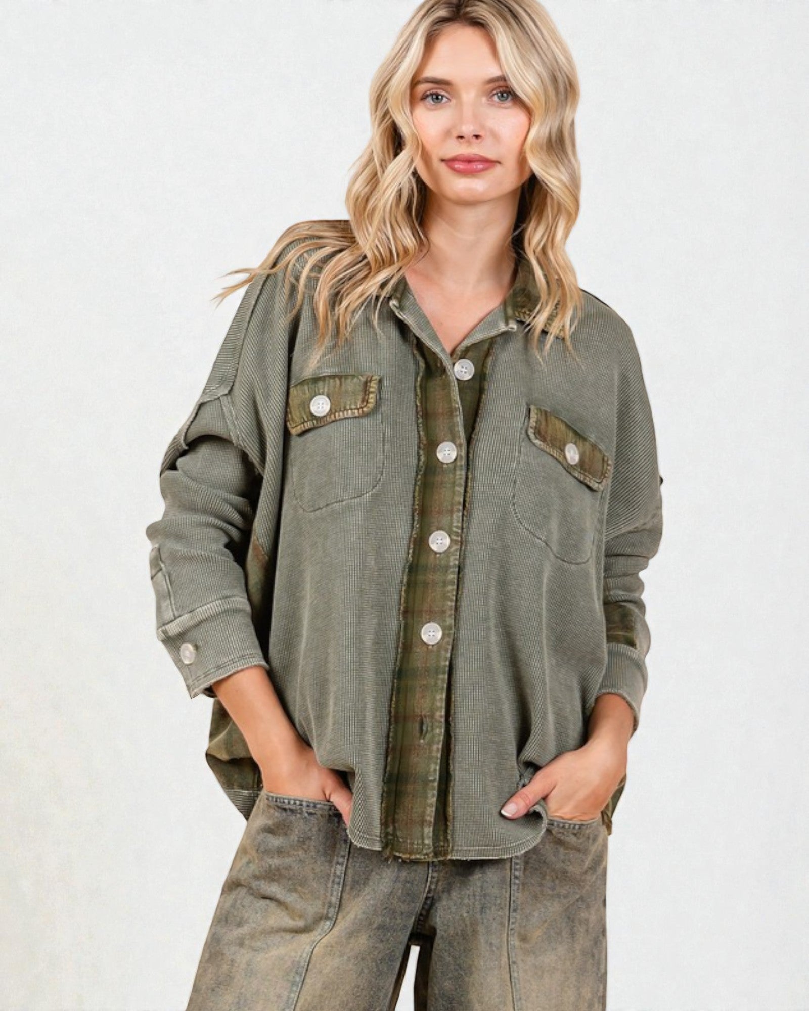Woman wearing an olive green jacket with button details on a white background